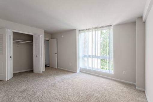A room with a carpeted floor and a sliding glass door at Charlestowne North Apartments, Greenbelt, MD, 20770