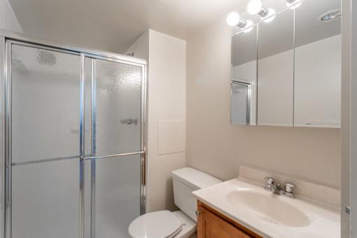 A bathroom with a toilet, sink, and mirror at Charlestowne North Apartments, Maryland, 20770