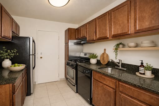 A kitchen with black appliances and wooden cabinets.