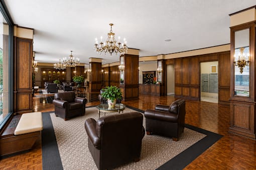 A large room with a chandelier and leather chairs.
