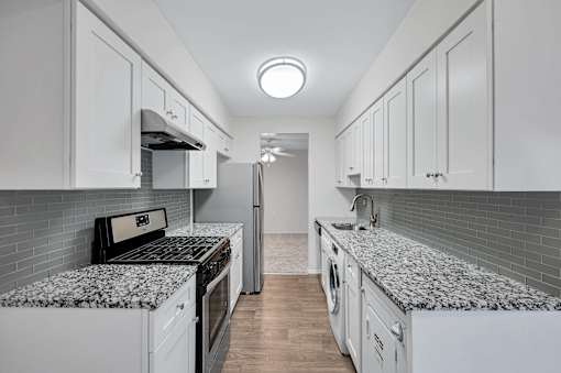 Kitchen with refrigerator and white cabinets at Columbia Pointe, Columbia, MD
