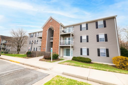 a picture of an apartment building with a sidewalk in front of it
