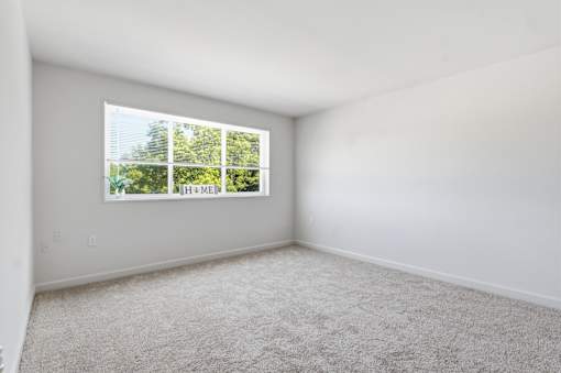 A room with a window that has a view of trees and the word "MEM" on it.