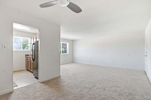 A room with a ceiling fan and a carpeted floor.