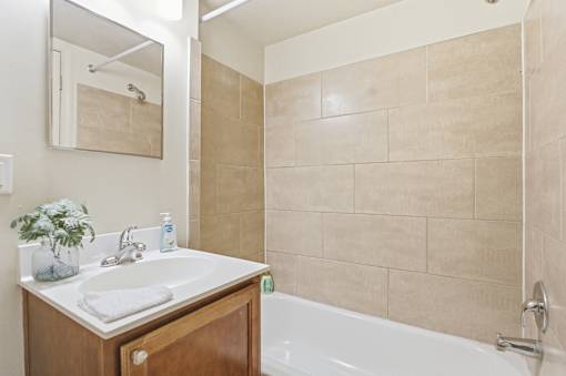 A bathroom with a white sink and a white bathtub.