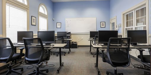 a classroom with computers and desks and a whiteboard at Overland Gardens, Landover, MD 