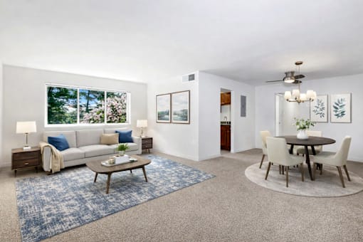 A living room with a couch, a coffee table, and a dining table.