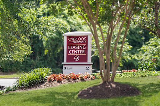 A sign for the Overlook Apartments Leasing Center sits in front of a tree.