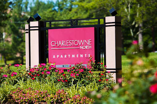 A sign for Charlestowne North Apartments is surrounded by flowers at Charlestowne North Apartments, Greenbelt, MD