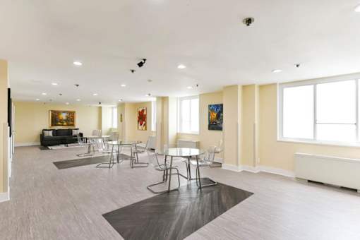 A spacious living room with a grey floor and white walls at Ashton Heights Apartments, Suitland