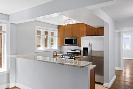 a kitchen with wood cabinets and a granite counter top