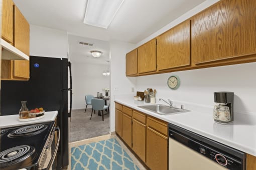 kitchen at Creekside at Taskers Chance in Frederick, MD with black appliances, wood cabinets and white countertops