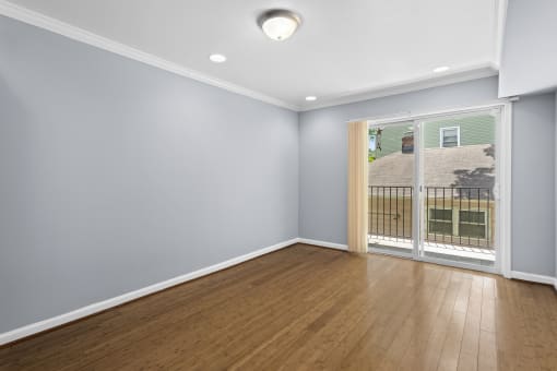 a bedroom with a sliding glass door and hardwood floors