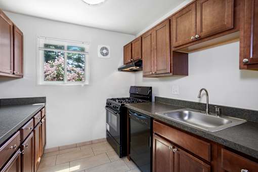 A kitchen with brown cabinets and a black stove top oven.