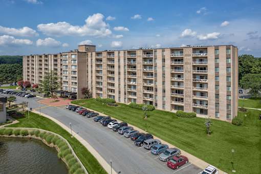 A large apartment building with a parking lot in front.