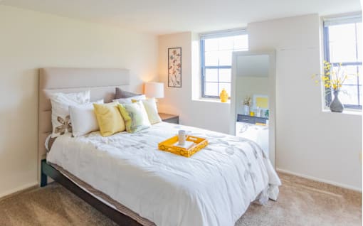 A bedroom with a large bed and a mirror on the wall at Dutch Village Apartments, Maryland