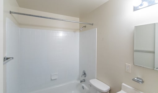 A white bathroom with a toilet, sink, and bathtub at Dutch Village Apartments, Baltimore, MD