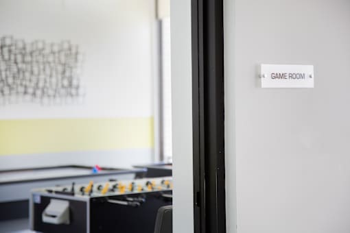 A foosball table is in a room with a sign that says Game Room.