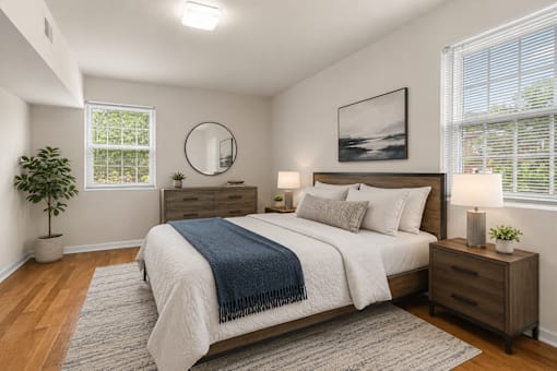 Furnished bedroom with modern wood furniture at University Landing Apartments, Silver Spring