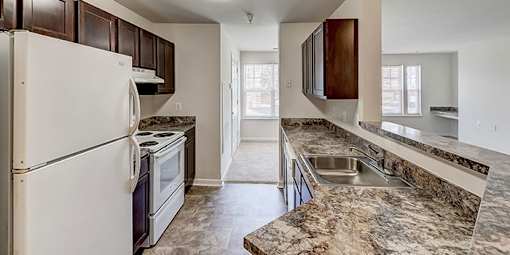 a kitchen with white appliances and granite counter tops at Windsor Crossing, Maryland, 20746