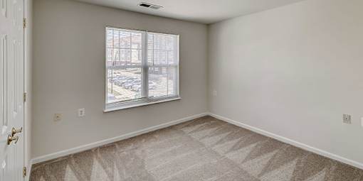 an empty room with white walls and a window at Windsor Crossing, Suitland, 20746 