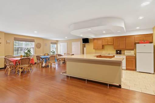 A kitchen with wooden floors and a white refrigerator.