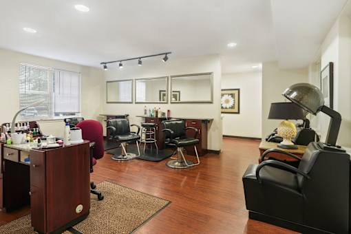 A room with a desk, chairs, and a mirror.