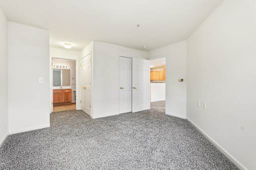 A large empty room with a carpeted floor and white walls.