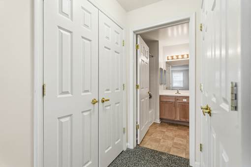 A hallway with white doors and a brown cabinet in the middle.