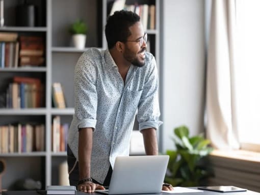 a man standing in front of a laptop computer