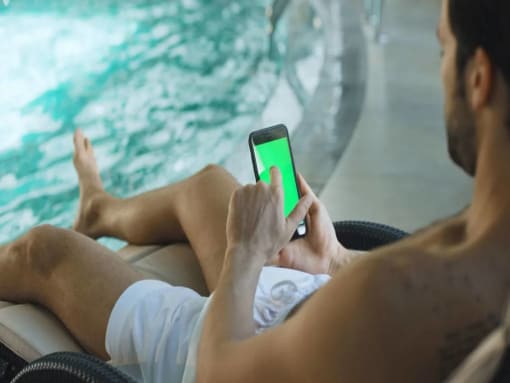 a man sitting in a chair holding a cell phone