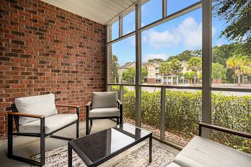 Two chairs and a coffee table in front of a window.