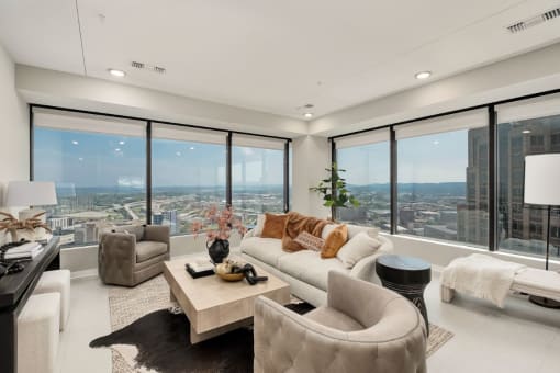 the living room has floor to ceiling windows and a view of the city at The 600 Apartments, Alabama