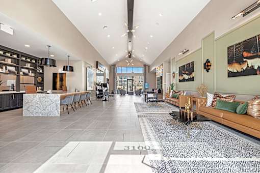 A spacious interior of a modern building with a long hallway and a kitchen area.