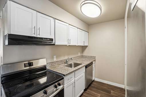 A kitchen with white cabinets and a black stove top oven.