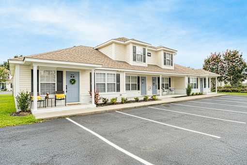 A two-story building with a parking lot in front.