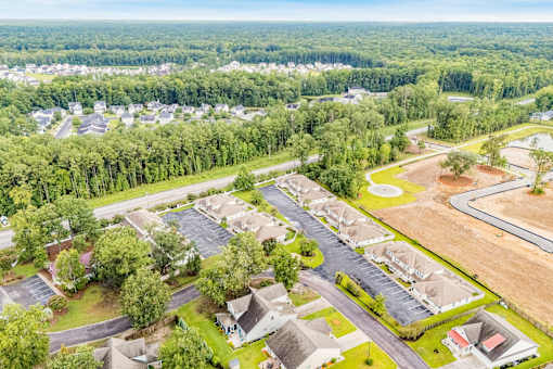 A bird's eye view of a residential area with houses and a parking lot.