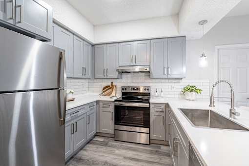 A modern kitchen with a stainless steel refrigerator and a double oven.