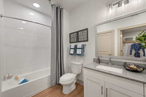 A white bathroom with a toilet, sink, and bathtub.