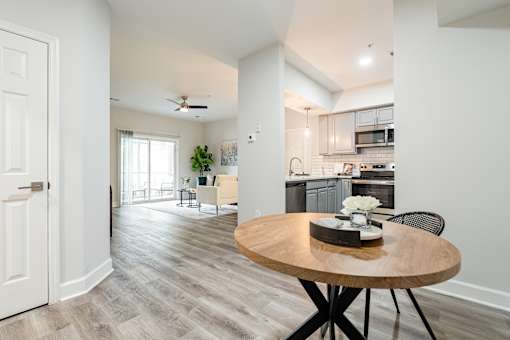 A modern kitchen with a round wooden table and chairs.