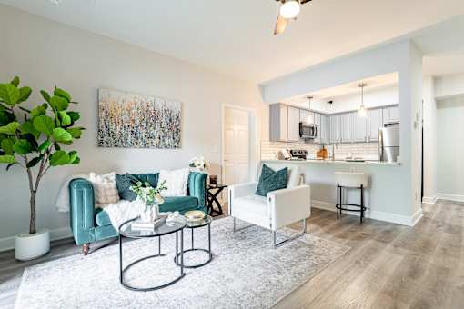 A living room with a white couch, a green chair, and a coffee table.