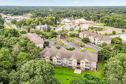 A bird's eye view of a large apartment complex surrounded by trees.