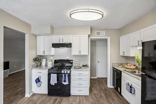 A kitchen with white cabinets and a black stove top oven.