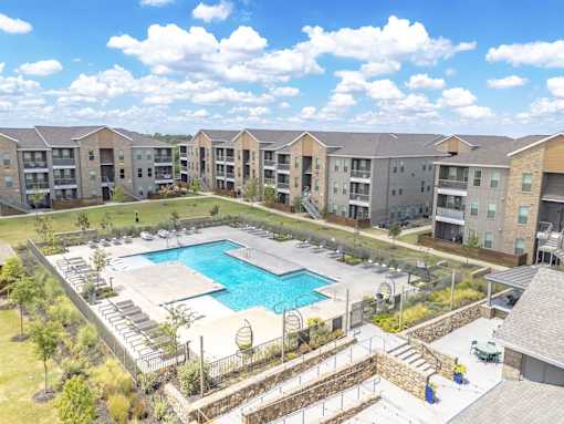 A swimming pool in a residential area surrounded by apartment buildings.