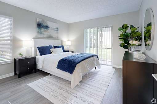 A bedroom with a large bed and a painting on the wall.