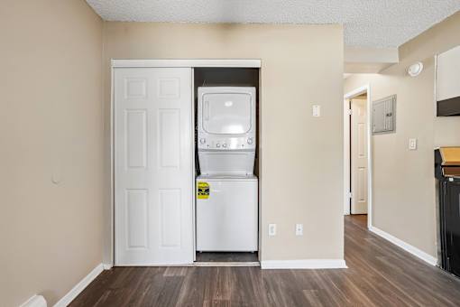 A white door is open to a small kitchen with a white fridge.