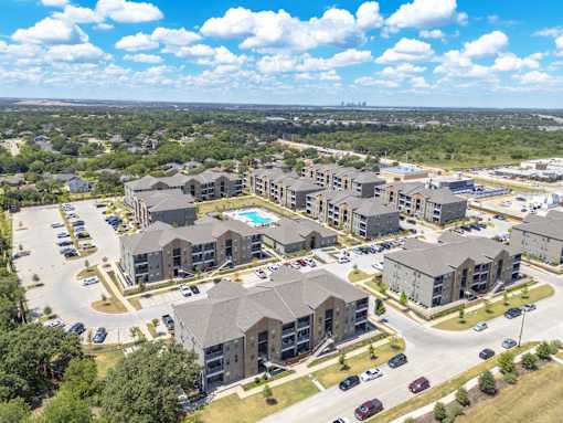 A large apartment complex with a swimming pool in the middle.