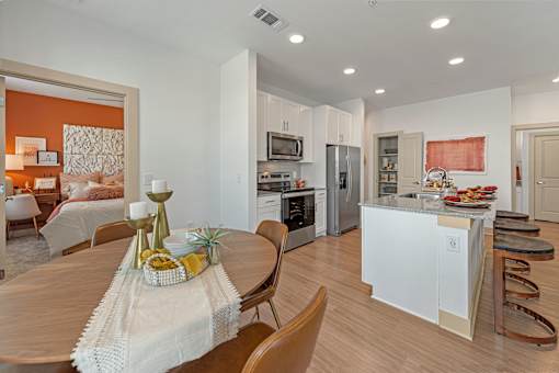 A modern kitchen with a dining table set for two.