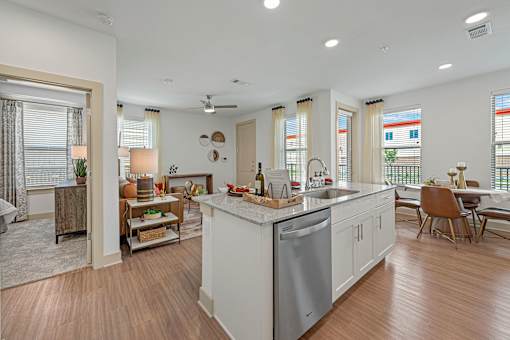 A modern kitchen with a white island and wooden floors.