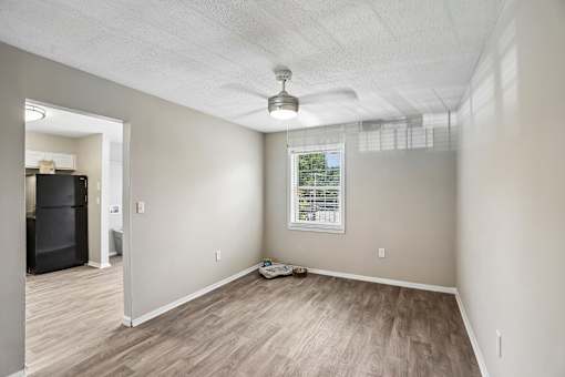 A room with a window and a ceiling fan.